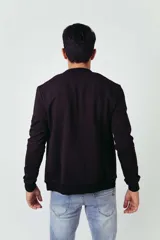 Campera tipo bomber de frisa color azul marino, con cierre frontal y bolsillos laterales.