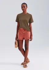 Remera color beige de corte clásico, con cuello redondo y mangas cortas.