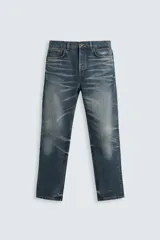 Pantalón de jean azul con efecto lavado, corte recto y largo al tobillo.