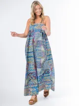 Vestido largo de algodón con estampado geométrico multicolor, corte cuadrado, elástico en la espalda y tirantes finos. Incluye aplique de flor desmontable.