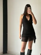 Vestido corto color marrón, con escote halter, espalda descubierta, corte ajustado y falda con volados.
