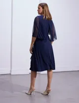 Vestido de fiesta azul marino de seda fría marca RM Richards, con escote en V cruzado, broche dorado en la cintura y mangas cortas de gasa.