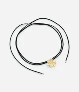 Collar choker con cordón negro ajustable y colgante de flor dorada.
