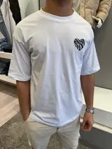 Remera blanca de algodón con corte oversize y estampado en la espalda de un corazón roto con diseño de cebra y la frase "very good".