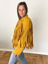 Campera de gamuza sintética color azul con flecos largos en mangas y espalda, corte recto con solapas clásicas.