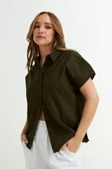 Camisa gris sin mangas de lino con cuello clásico y cierre frontal con botones.