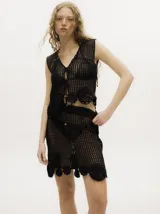 Top negro de algodón tejido al crochet, con diseño calado, apliques florales y tirantes finos.