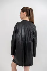 Chaqueta negra de cuero ovino con corte recto y lazo de ajuste en la cintura.