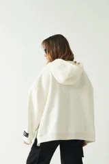 Buzo verde oscuro de corte recto y amplio, con capucha con cordones regulables y bolsillo frontal con cierre.