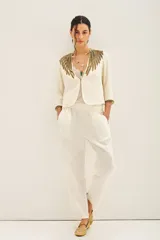 Saco corto color crema con escote en V y mangas 3/4. Confeccionado en viscosa crepe con bordado de mostacillas, canutillos y lentejuelas doradas.