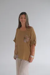 Blusa color camel de corte holgado, con cuello redondo, mangas cortas con dobladillo y apliques de tela estampada en el frente.