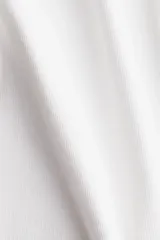Musculosa blanca de punto de algodón acanalado, corte entallado, cuello redondo y ribete fino en escote y sisas.