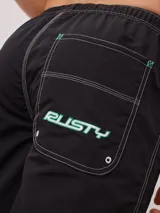 Short de baño azul marino con cintura elástica ajustable con cordón, bolsillos laterales y logo de la marca Rusty estampado en azul en la pierna izquierda.