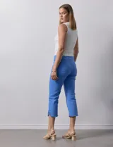 Pantalón capri azul de algodón. Delantera con bolsillos simulados, trasera con bolsillos aplicados. Pretina ancha elastizada, corte recto. Ruedo con aplique entrelazado, tachas y terminación desflecada.