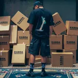 Remera negra de algodón con estampa frontal del box logo "Ahogado" de R.Flakkkk, estampa trasera del logo del álbum Ahogado y micro logo de KABOA & "Turro Original" en las mangas.