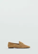 Mocasín de cuero color camel con punta fina y detalle de hebilla metálica dorada.