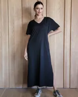 Vestido negro de corte recto, largo midi, con escote en V y mangas cortas.