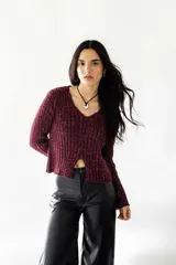 Buzo bordeaux de lurex con tajo delantero y mangas largas.