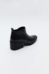 Botín negro de cuero sintético con punta fina y taco ancho de 6cm.