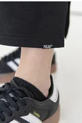 Falda midi negra de tejido de punto acanalado, corte ajustado y abertura lateral.