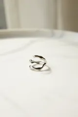 Anillo plateado de acero quirúrgico con diseño irregular y ajustable.