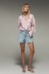 Camisa blanca de modal con cuello solapa, manga larga con puños abotonados, cierre frontal con botones y dos bolsillos con solapa en el pecho.