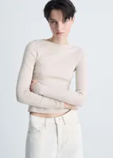 Camiseta color beige de algodón con cuello barco y mangas largas.