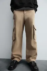 Pantalón cargo color beige, de corte relaxed fit, con bolsillos frontales, traseros con solapa y bolsillos laterales tipo parche con solapa.