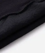 Buzo tipo canguro de color gris melange, con capucha, bolsillo canguro frontal y puños y bajo acanalados. Corte recto.