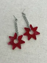Par de caravanas colgantes con diseño de estrella roja brillante y cadena de eslabones plateados.