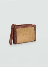 Billetera pequeña color beige con textura de rafia y borde de cuero marrón. Tiene cierre metálico a presión, logo en relieve, seis ranuras para tarjetas y cierre de cremallera.