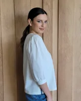 Blusa blanca de mangas 3/4 abullonadas con escote en V.