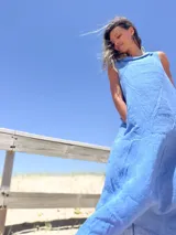 Vestido largo celeste de lino, corte amplio y cuello caído.