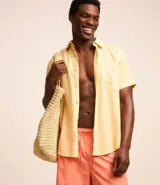 Camisa de hombre de manga corta color arena, confeccionada en lino y algodón. Tiene cuello camisero, corte clásico, cierre frontal con botones, un bolsillo en el pecho y ruedo recto.