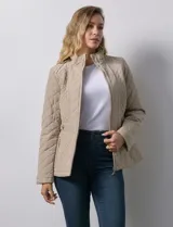 Campera capitoneada color beige, marca Gallery. Con cierre central, bolsillos delanteros con cierre, cinto de ajuste regulable en la cintura y forro interno a tono.