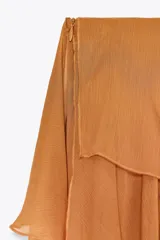 Falda midi color ocre con volantes asimétricos y cierre lateral con cremallera oculta.