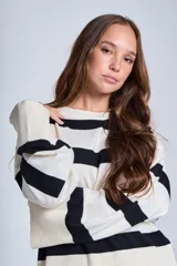 Sweater Bremer con cuello redondo y mangas largas ligeramente amplias. Diseño a rayas horizontales en color crudo y negro.