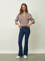 Pantalón de jean azul oscuro, corte Oxford (acampanado desde la rodilla), tiro medio/alto.