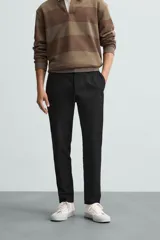 Pantalón largo de vestir gris claro con estampado de cuadros, corte slim fit y cintura elástica. Confeccionado en tejido con alta elasticidad, bolsillos frontales y cierre frontal con cremallera y botón.