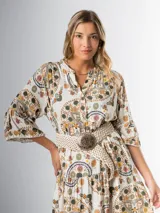 Vestido midi de algodón italiano, color blanco con estampado boho chic en tonos naranja, marrón y verde. Tiene corte oversized, mangas 3/4 con volados y cinturón de soga trenzada con hebilla circular.