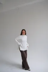 Sweater blanco de corte recto con cuello alto y aberturas laterales.