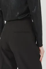 Pantalón negro de vestir, de tiro alto y corte palazzo.
