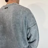 Buzo celeste con efecto gastado, corte oversize, cuello redondo y puños y ruedo acanalados.