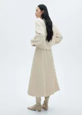 Sweater color crema con cuello perkins y paneles en contraste.