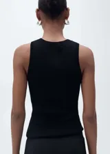 Musculosa blanca de tejido de punto fino, cuello redondo, tirantes anchos y diseño entallado.