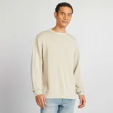 Sweater de punto fino color beige, de corte clásico y cuello redondo.
