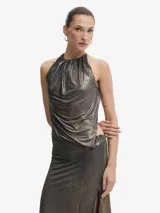 Vestido largo de tejido fino y muy elástico, con acabado metalizado en tonos negro y dorado. Presenta un diseño entallado, escote halter con fruncido y espalda abierta. Incluye un body integrado con cierre de tres corchetes y una abertura lateral alta en la falda.