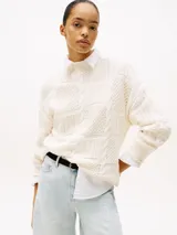 Sweater color crema de punto trenzado con cuello redondo y corte holgado.