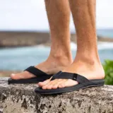 Sandalias Reef Cushion Phantom negras con plantilla acolchada y tira de cuero sintético con logo de la marca.