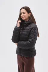 Campera acolchada negra, con cuello alto y cierre frontal. Presenta un diseño de costuras horizontales y verticales que crean un patrón de rombos o diamantes.